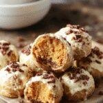 A plate of no-bake pumpkin Oreo truffles decorated with orange and white sprinkles, perfect for fall celebrations.